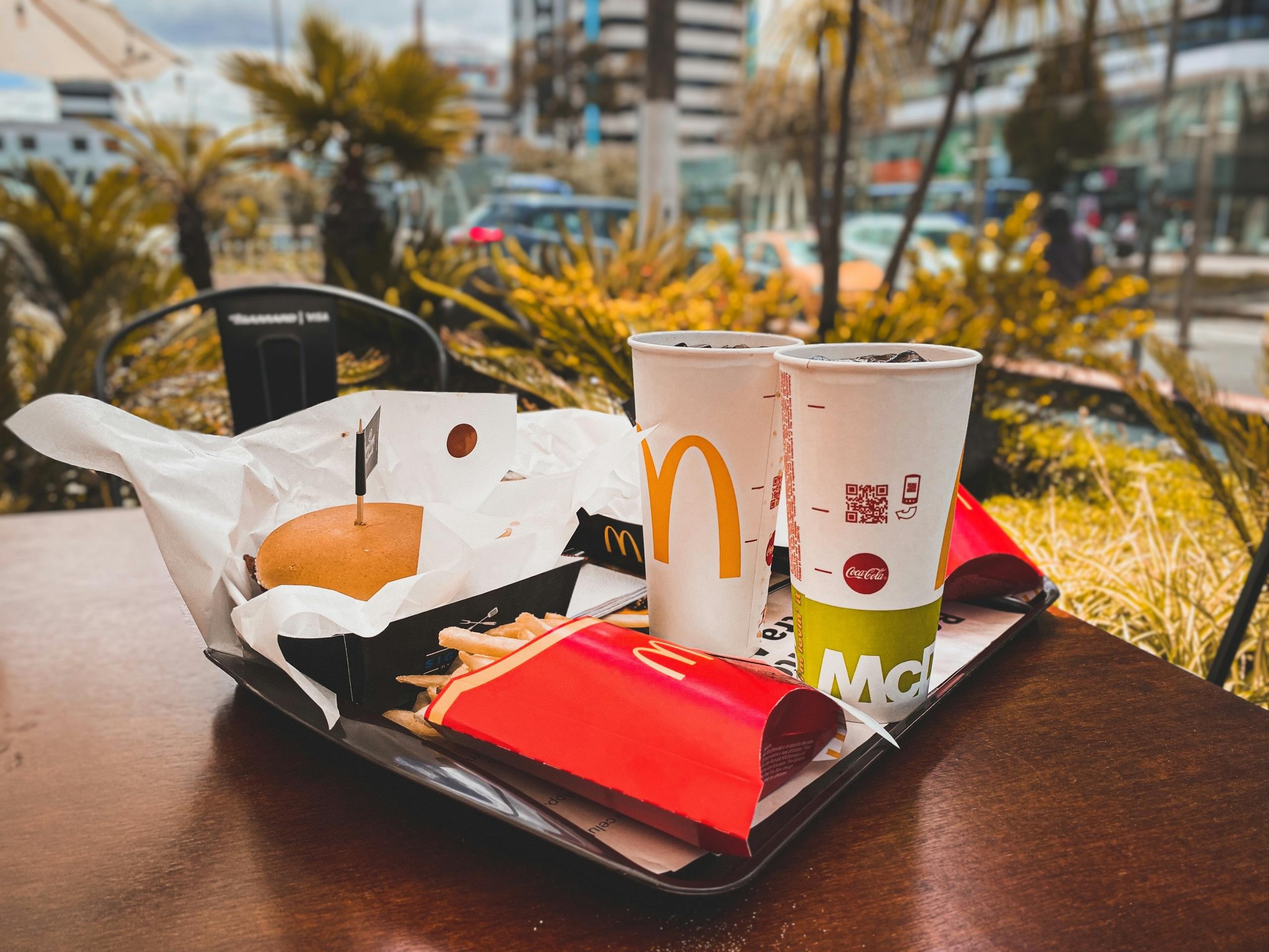 Un repas de restauration rapide appétissant avec burger, frites et boissons sur une table en extérieur