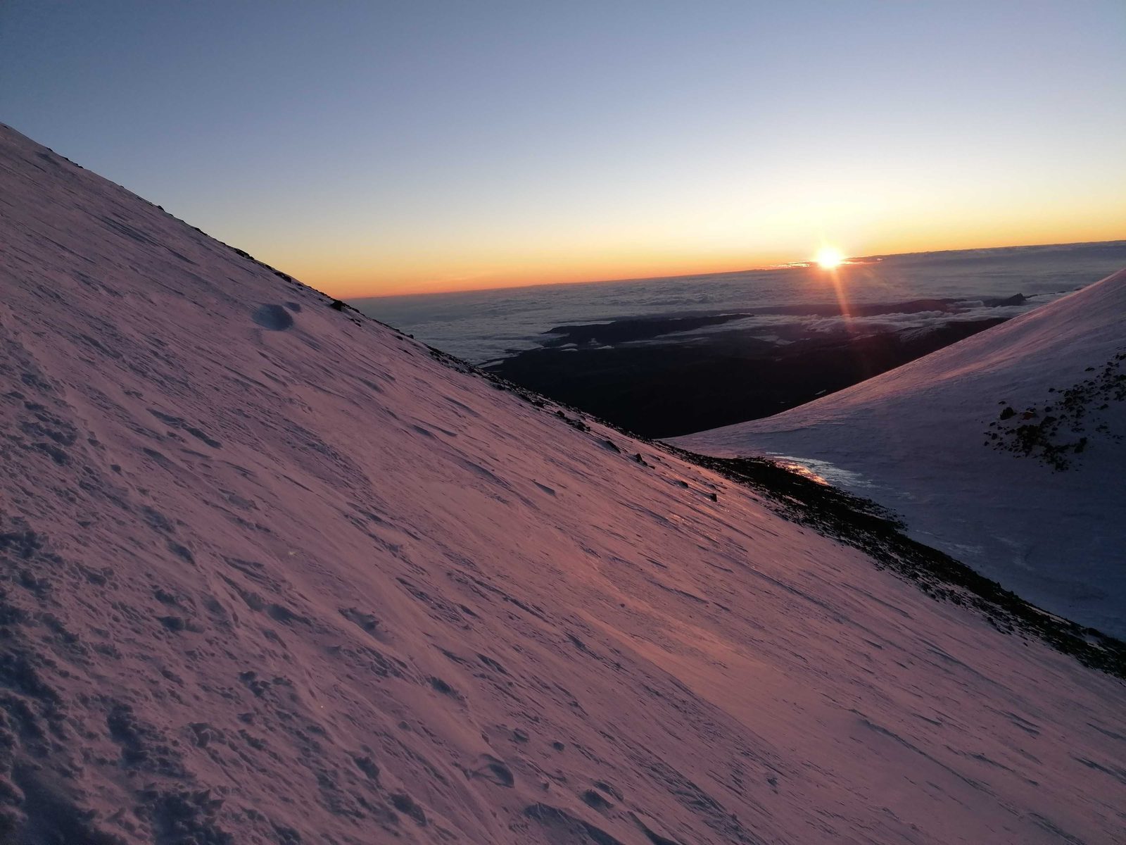 Lever de soleil entre les deux sommets de l'Elbrouz, au-dessus d'une mer de nuages