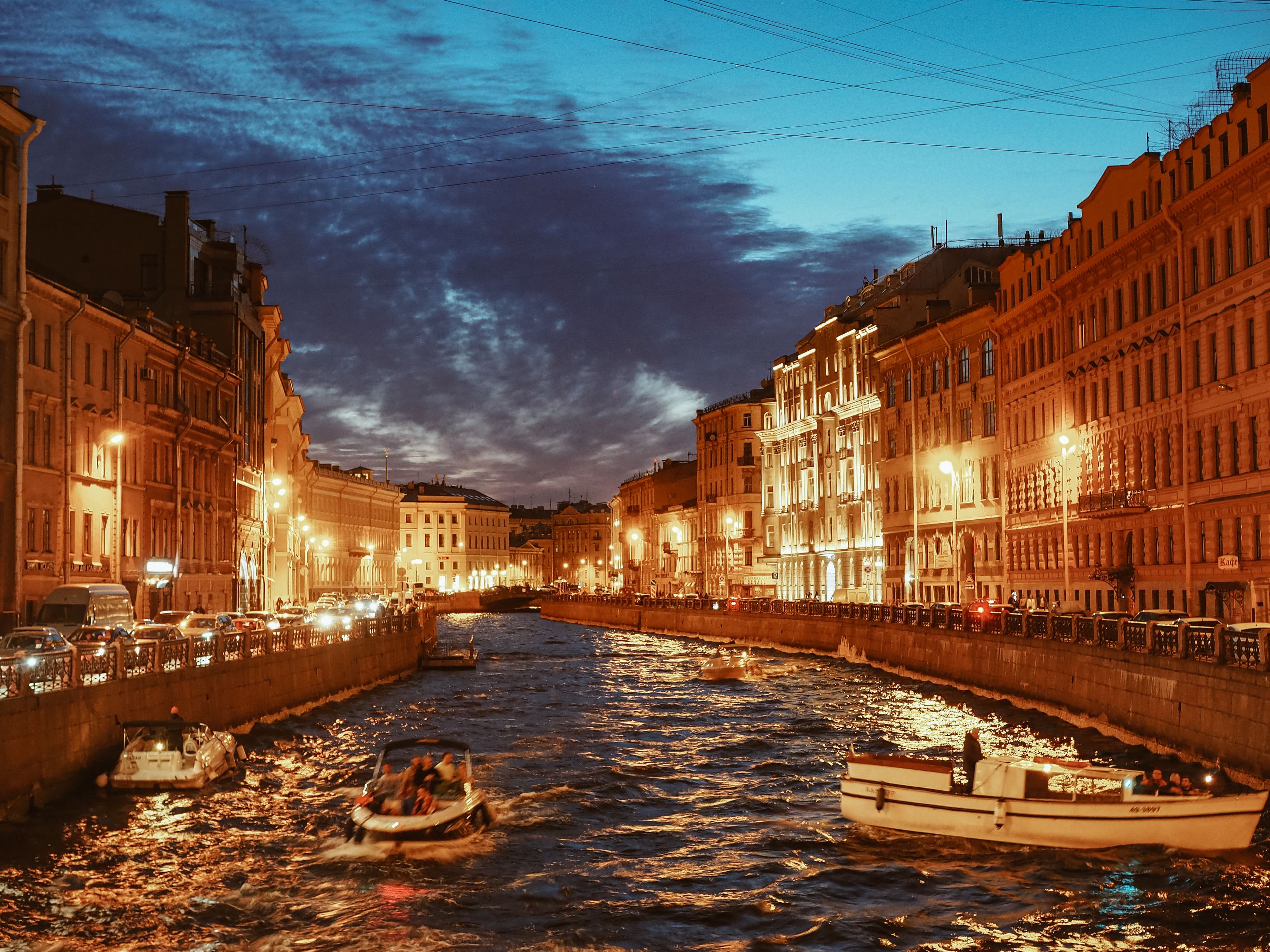 Vue au crépuscule d'un canal de Saint-Pétersbourg avec des bâtiments illuminés et des bateaux