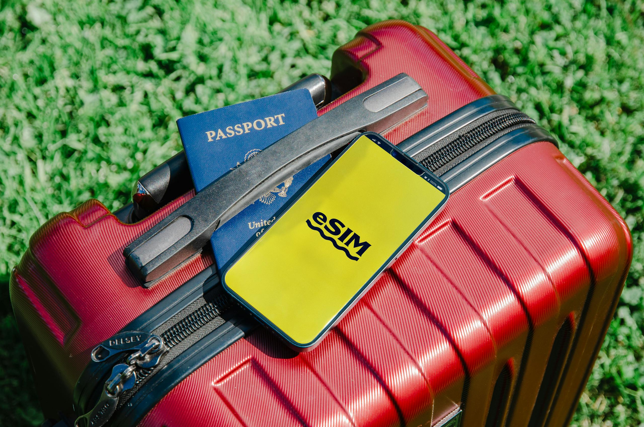 Smartphone avec une eSIM, passeport et valise rouge prêts pour un voyage en Russie